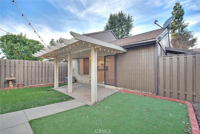 exterior space with a shingled roof, fence, a lawn, and a patio