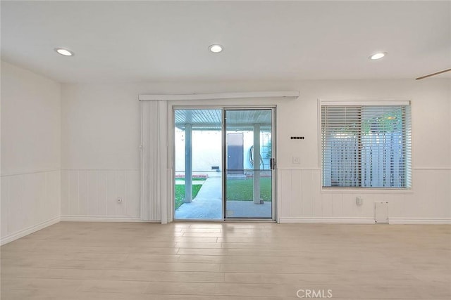 interior space with light wood-type flooring, wainscoting, and recessed lighting