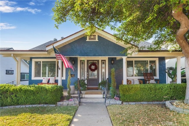 bungalow-style home with a porch and a front lawn