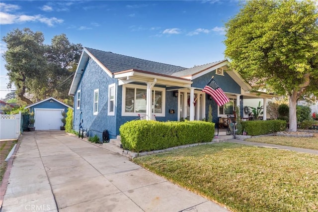 bungalow-style home with a garage, a porch, an outbuilding, and a front lawn