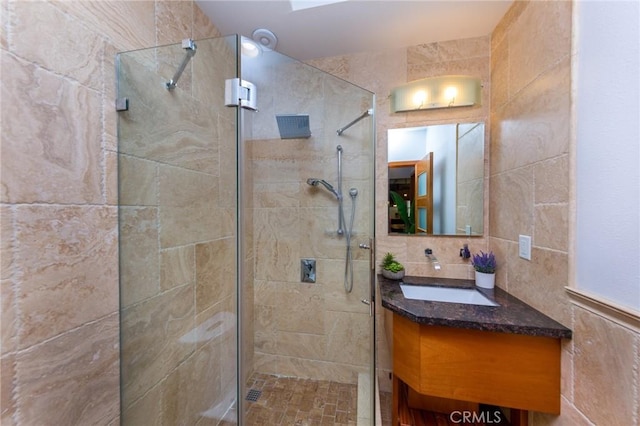 bathroom with decorative backsplash, vanity, an enclosed shower, and tile walls