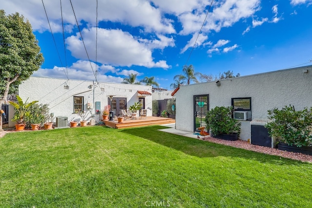 back of property with a wooden deck, central AC, a lawn, and cooling unit