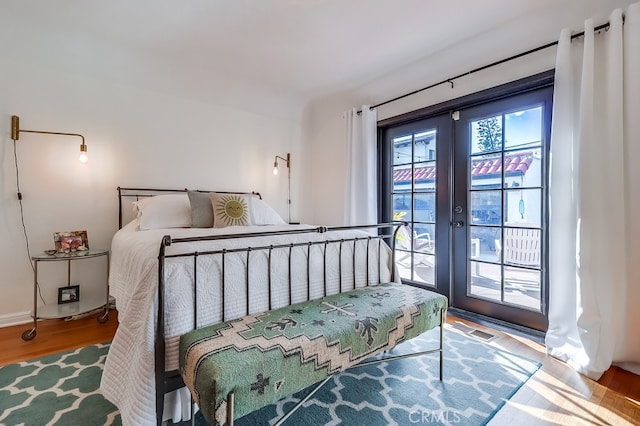 bedroom featuring french doors, access to exterior, and light hardwood / wood-style floors