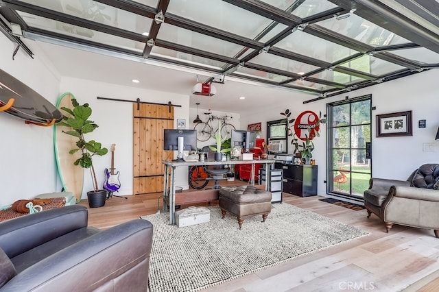 living room with a barn door and light hardwood / wood-style floors