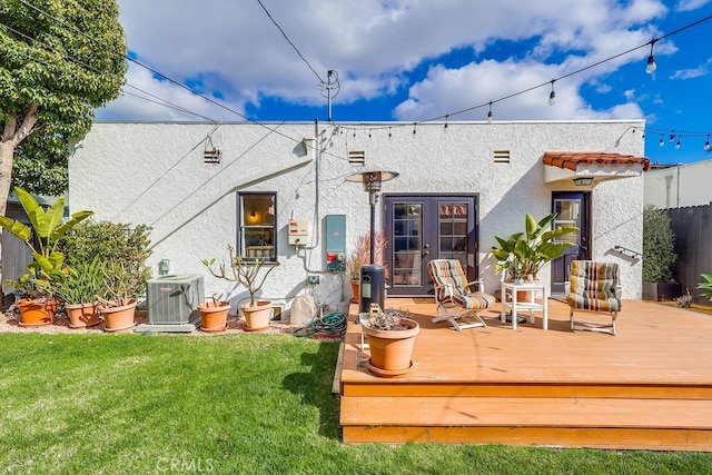 rear view of house with french doors, a yard, a deck, and cooling unit