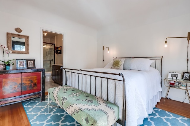 bedroom with wood-type flooring and ensuite bathroom