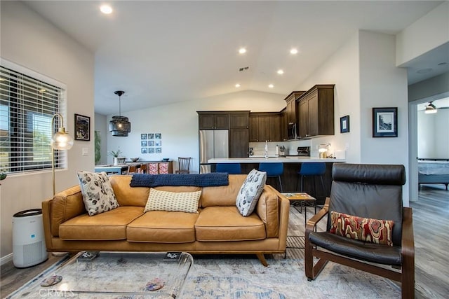 living room with lofted ceiling and light hardwood / wood-style flooring