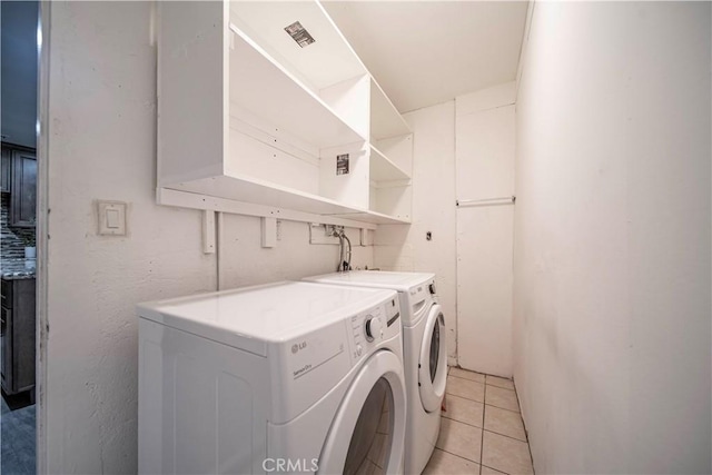 clothes washing area featuring independent washer and dryer and light tile patterned floors