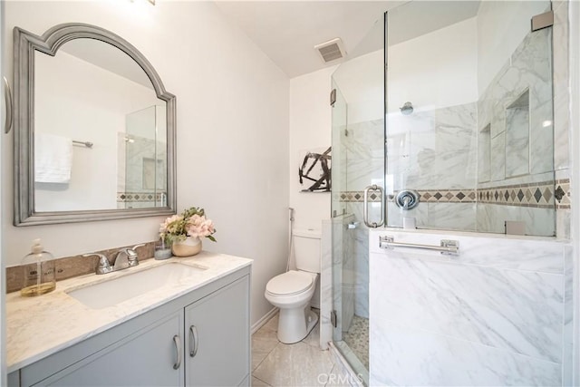 bathroom featuring vanity, a shower with shower door, and toilet