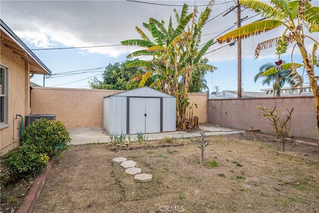 view of yard with central air condition unit and a storage unit