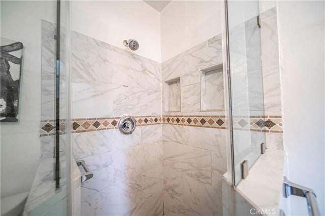 bathroom featuring a shower with shower door