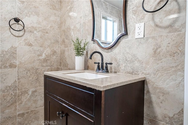 bathroom with vanity and tile walls