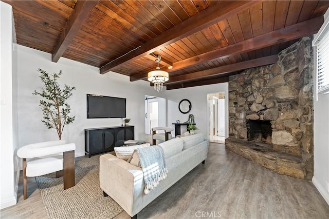 living room featuring beam ceiling, an inviting chandelier, wooden ceiling, a fireplace, and hardwood / wood-style floors