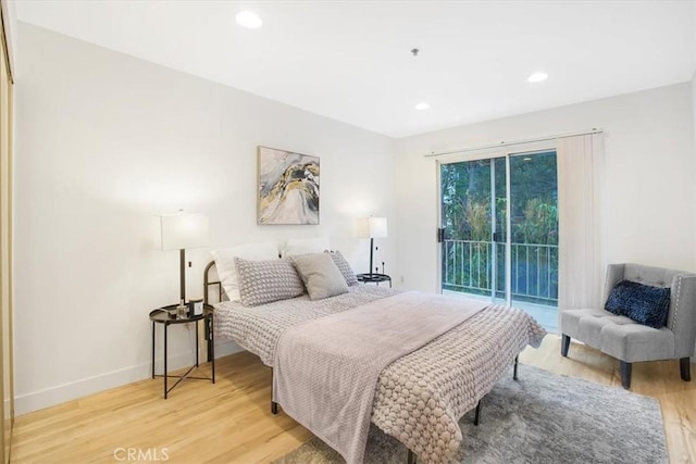 bedroom featuring access to exterior and hardwood / wood-style floors