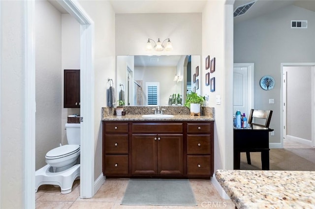 bathroom with tile patterned flooring, vanity, lofted ceiling, and toilet