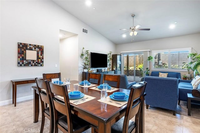 tiled dining space featuring ceiling fan and high vaulted ceiling