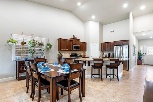 tiled dining area with high vaulted ceiling