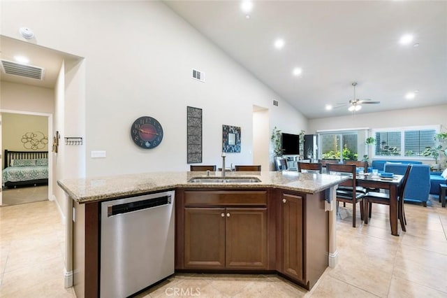 kitchen with an island with sink, light stone countertops, sink, and stainless steel dishwasher