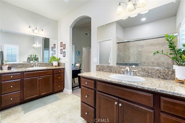 bathroom with walk in shower, vanity, and tile patterned flooring