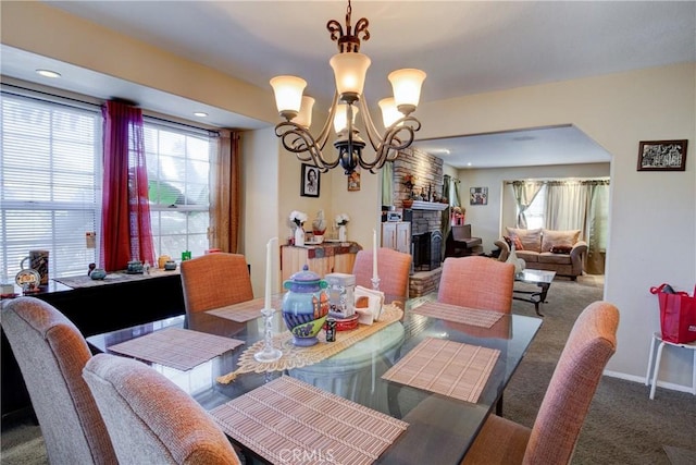 dining room with a fireplace, a notable chandelier, and carpet floors