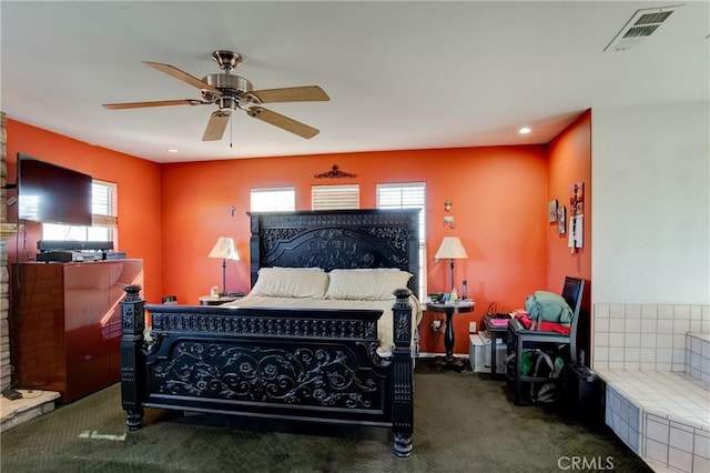 carpeted bedroom featuring multiple windows and ceiling fan