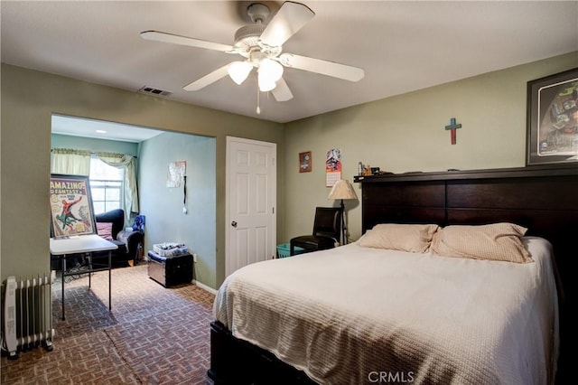 bedroom with radiator heating unit and ceiling fan