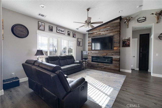 living room with lofted ceiling, a large fireplace, dark wood-type flooring, and ceiling fan