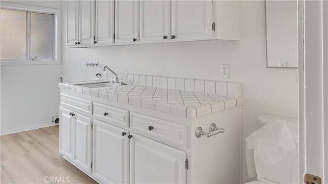 laundry room with sink and light hardwood / wood-style flooring