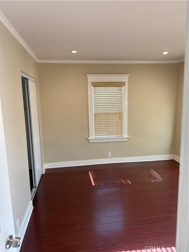 spare room with dark wood-type flooring and crown molding