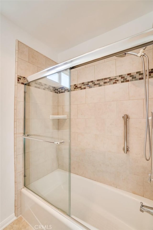 bathroom featuring bath / shower combo with glass door