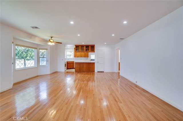 unfurnished living room with ceiling fan and light wood-type flooring