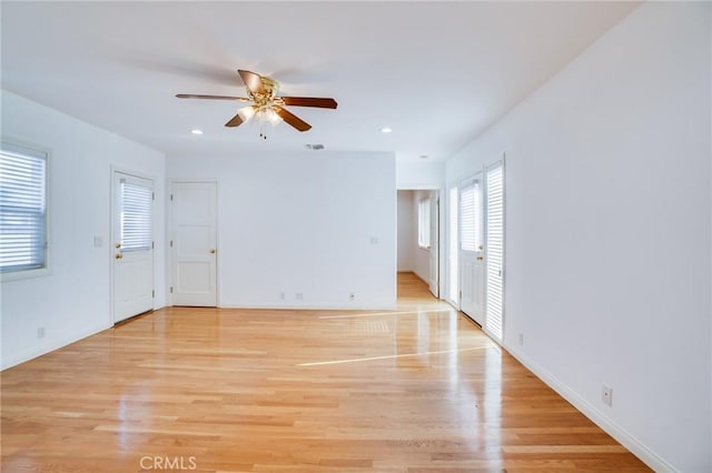 empty room featuring ceiling fan and light hardwood / wood-style flooring