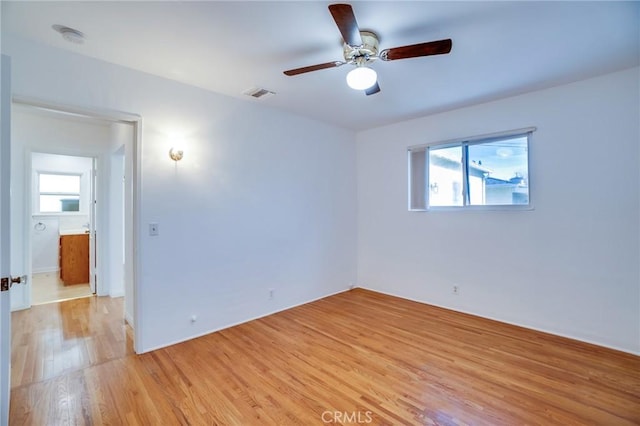 spare room with ceiling fan and light wood-type flooring