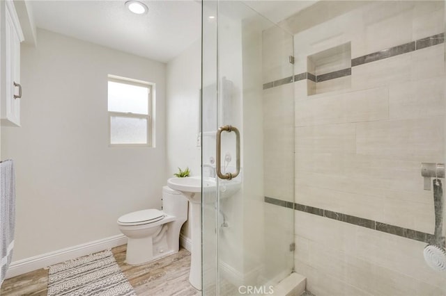 bathroom featuring toilet, an enclosed shower, and hardwood / wood-style floors