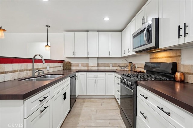 kitchen with sink, white cabinetry, hanging light fixtures, tasteful backsplash, and black appliances