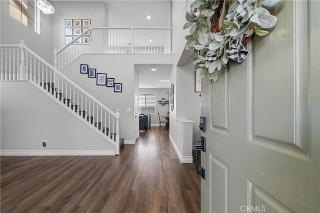 foyer entrance with dark hardwood / wood-style flooring and a high ceiling