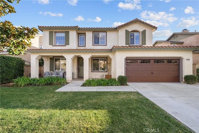 mediterranean / spanish home featuring a garage, a front lawn, and covered porch