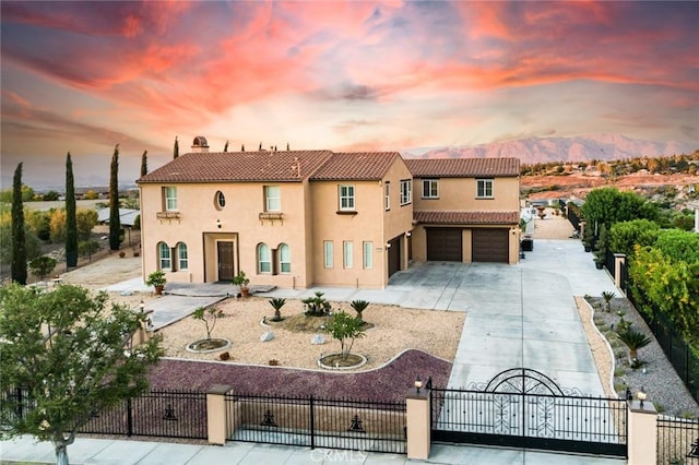 mediterranean / spanish-style home with a garage, driveway, fence, and stucco siding