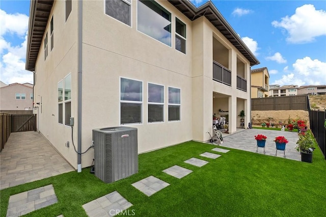 back of property with a yard, a patio area, and central air condition unit