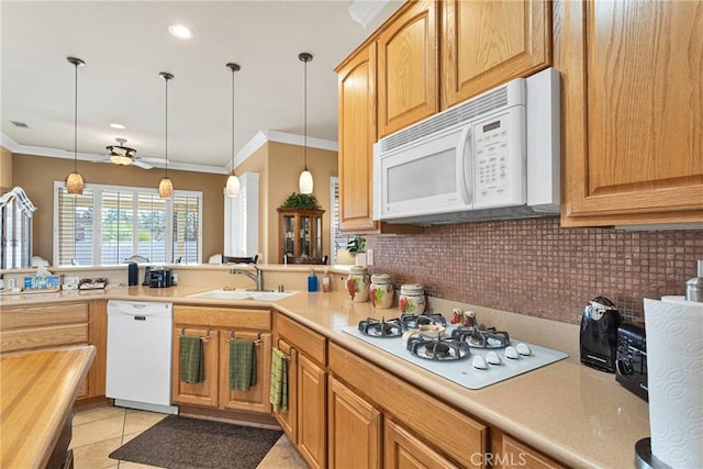 kitchen with ornamental molding, sink, white appliances, and decorative light fixtures