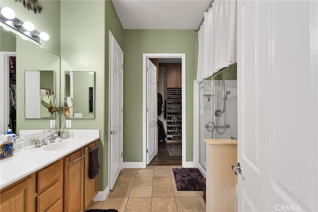 bathroom with tile patterned flooring, vanity, and an enclosed shower