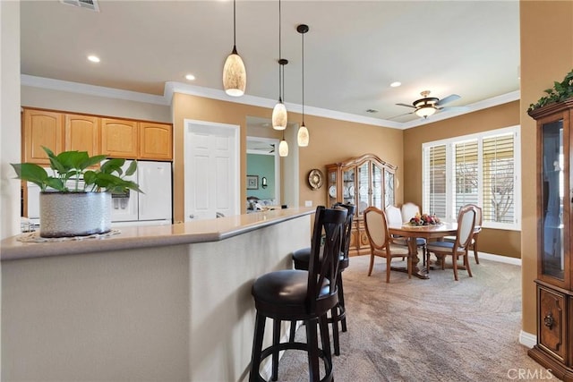 kitchen with ceiling fan, ornamental molding, white fridge with ice dispenser, decorative light fixtures, and light colored carpet