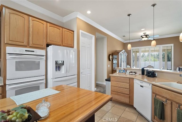 kitchen with light tile patterned flooring, sink, crown molding, hanging light fixtures, and white appliances