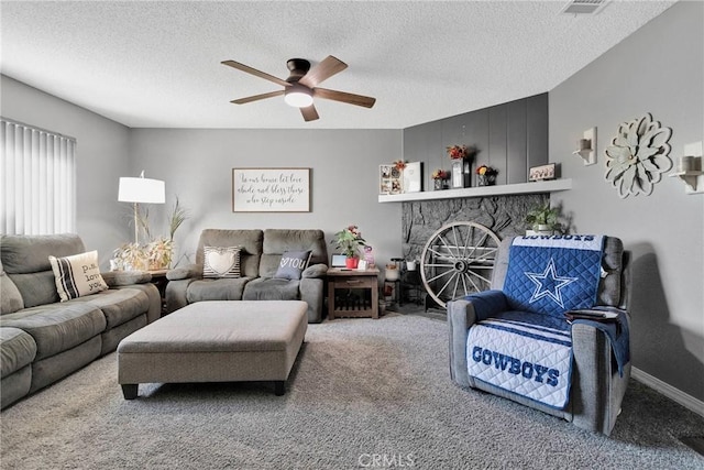 living area featuring a fireplace, visible vents, a ceiling fan, carpet flooring, and a textured ceiling