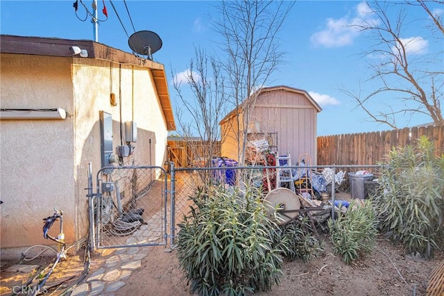 view of yard with a shed, a gate, and fence