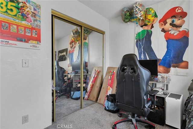 carpeted home office featuring a textured ceiling