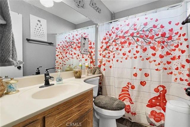 bathroom featuring walk in shower, vanity, and toilet