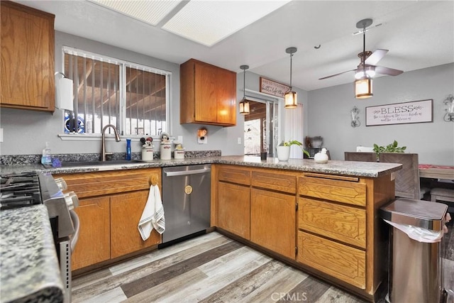 kitchen with decorative light fixtures, light hardwood / wood-style flooring, plenty of natural light, kitchen peninsula, and stainless steel appliances