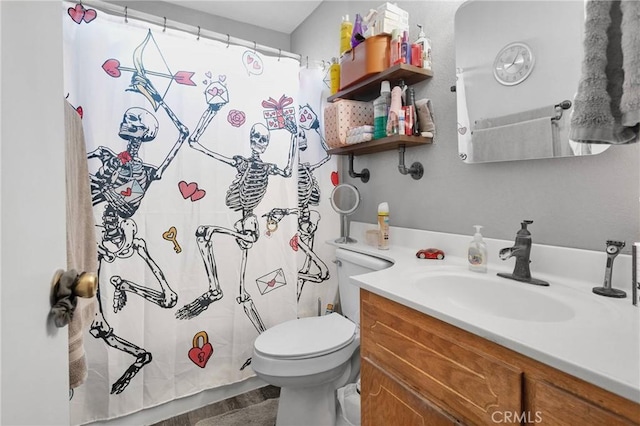 bathroom featuring toilet, a shower with shower curtain, and vanity