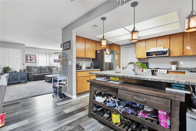 kitchen with decorative light fixtures, dark wood-type flooring, ceiling fan, and appliances with stainless steel finishes